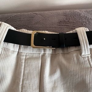 Black leather belt, brushed gold buckle.